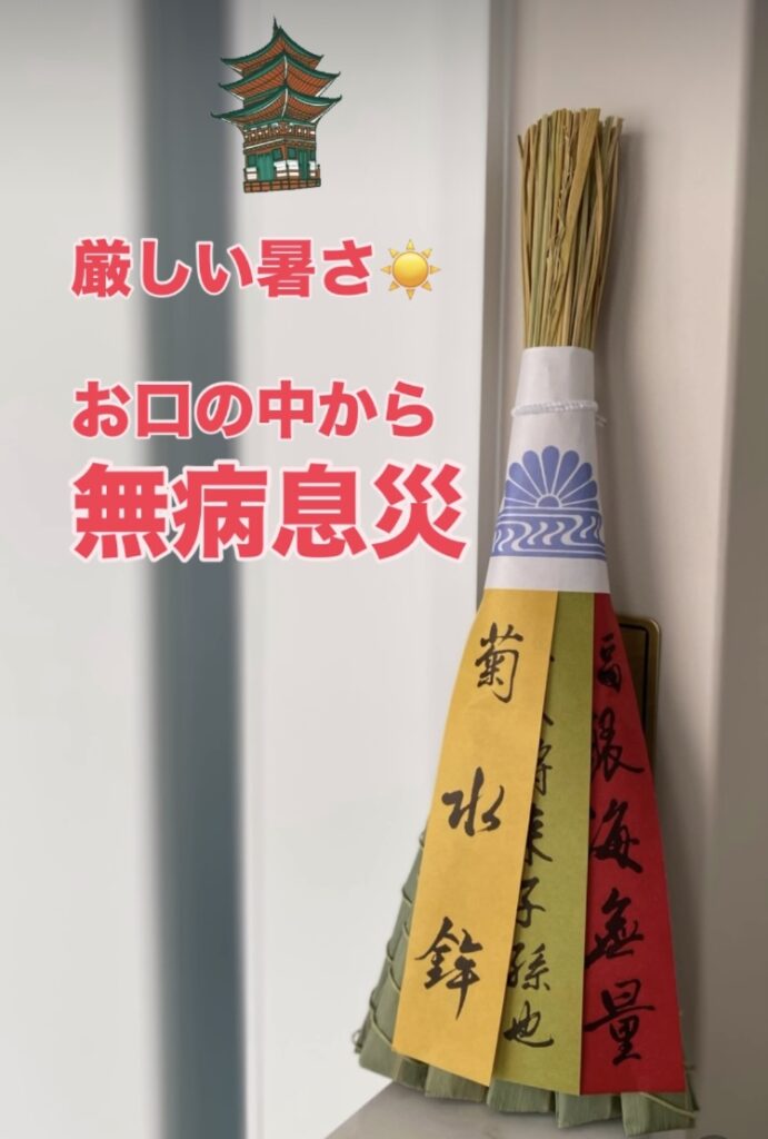 祇園祭の菊水鉾の厄除けちまきを背景にした画像。上部に八坂神社の五重塔のイラストと、『厳しい暑さ☀ お口の中から無病息災』という赤いテキストが配置されています。ちまきには、菊水鉾の紋が入った和紙、黄色・緑・赤の短冊(それぞれ『菊水鉾』などの墨書入り)が下がっています。